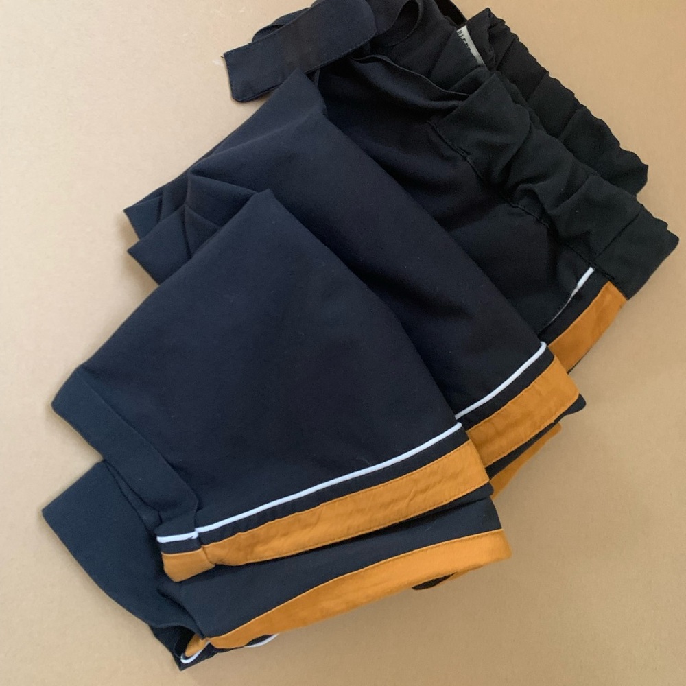 Black trousers with side stripe.